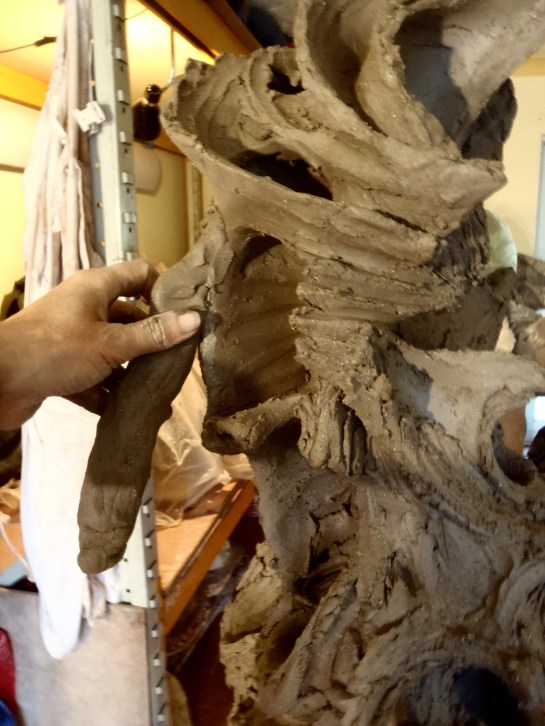 This bio-morphic head is being built on a clay armature with the techniques described in How to Make a Head. I use coils attached in exactly the same way as I would on a pot to get excellent joins. The coil is then pinched in the direction I want it to go.