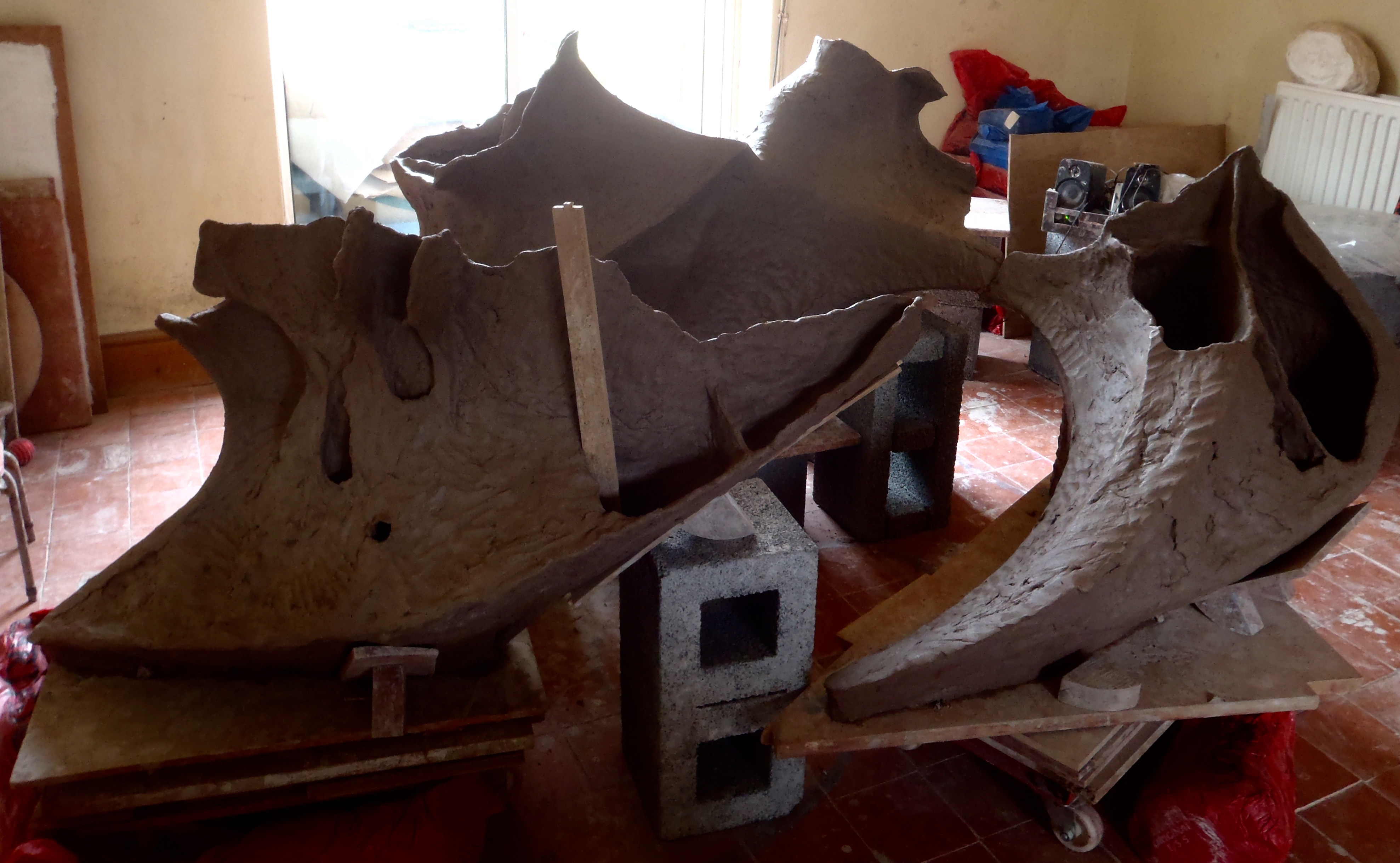 There is an internal support structure made of clay that will stay in place during the firing. It will help to support the sections when the sculpture is cut up so you need to plan them well in advance. Other materials like foam and wood are used inside just long enough for the clay to stiffen. External supports can be anything. They will need constant adjusting to accommodate shrinkage. I have a treasured collection of heavy-duty props and oddly shaped bits of wood.